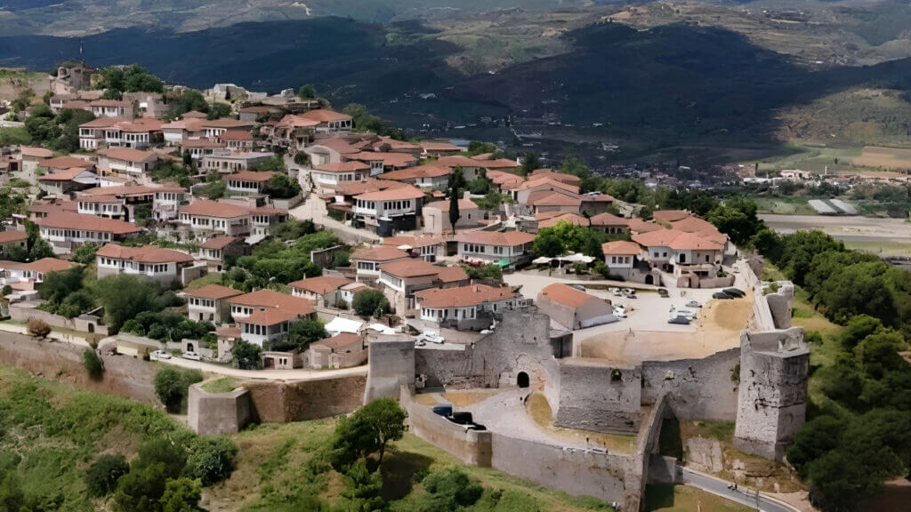 Aerial view of Berat Castle walls and red-roofed houses above the surrounding hills
