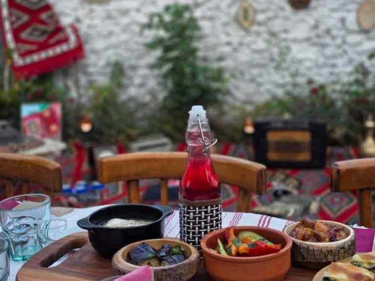 Table covered with many small bowls of traditional food and wine at a Shkodra food tasting