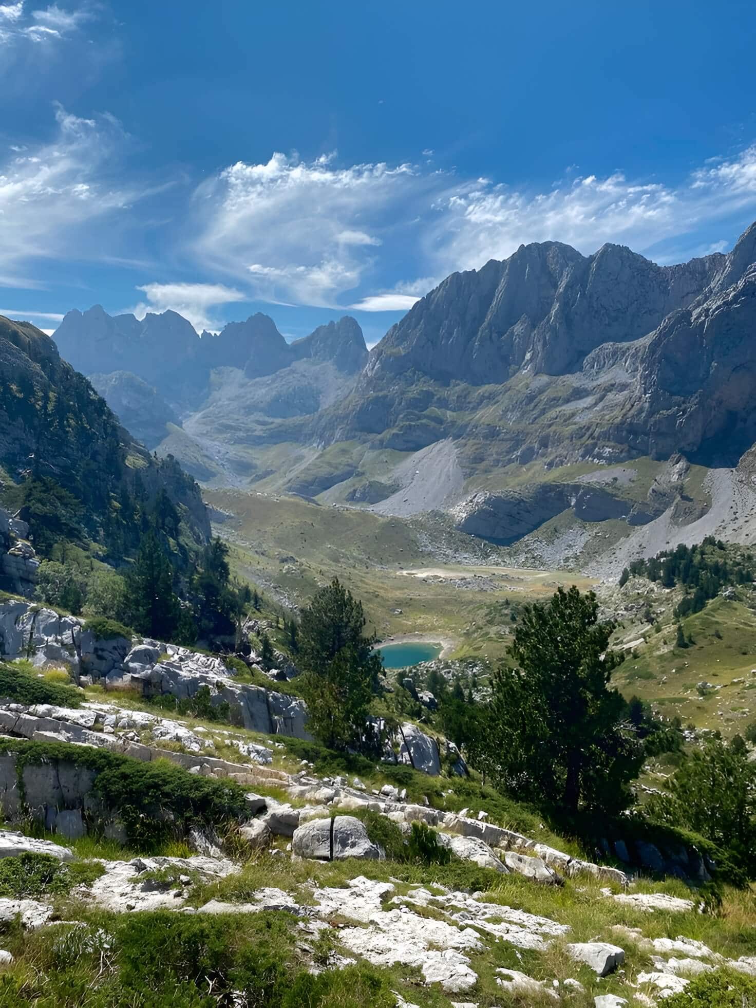 A winding mountain road opening into the Albanian Alps near Theth