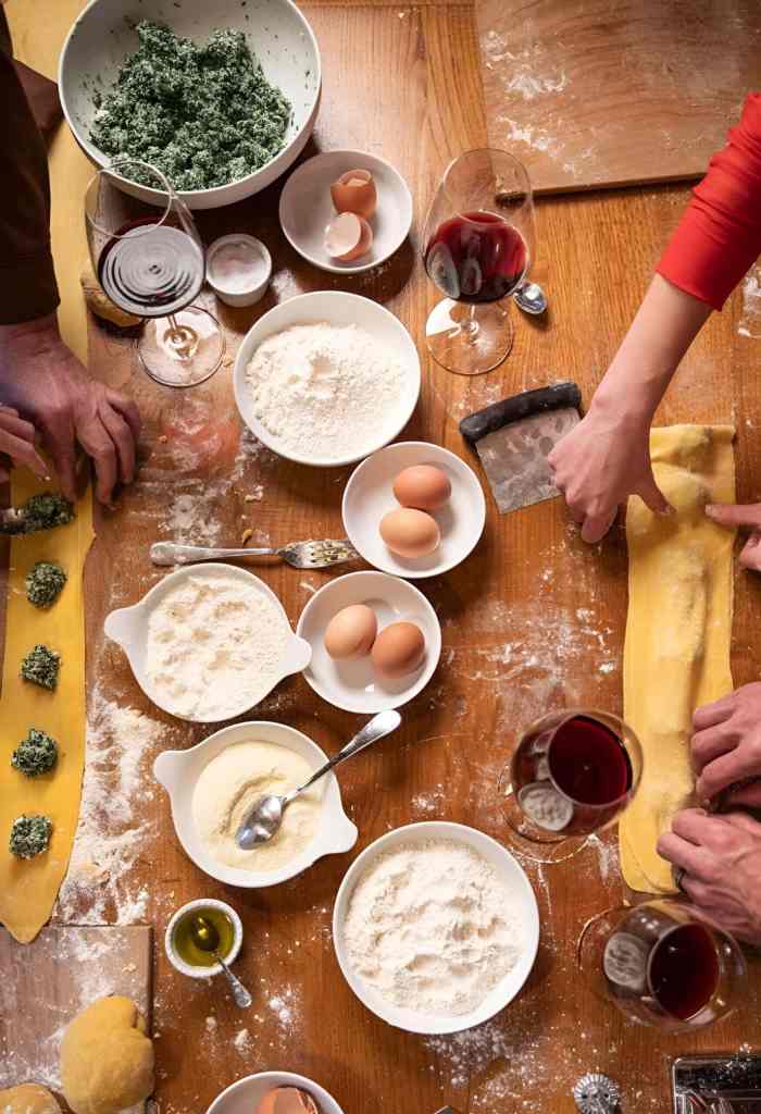 Fresh ingredients and hands making pastry at an Albanian cooking class in Tirana