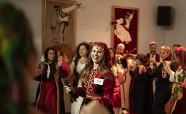 Performers and guests in traditional costume mingling at an Albanian folklore night in Tirana