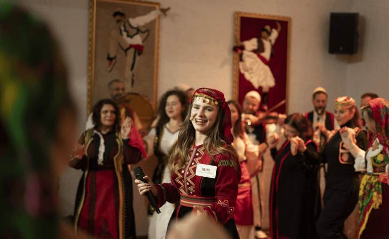Performers and guests in traditional costume mingling at an Albanian folklore night in Tirana
