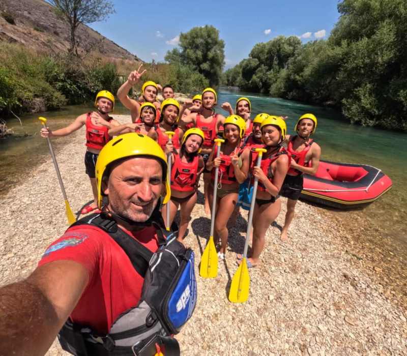 A rafting guide taking a selfie with the group on the bank of the Bistrica River near Saranda