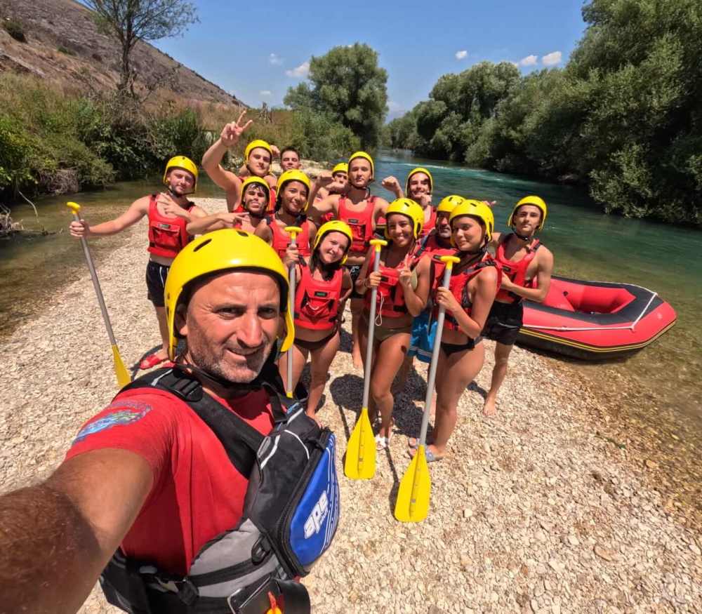 A rafting guide taking a selfie with the group on the bank of the Bistrica River near Saranda