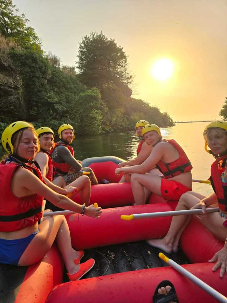 A group rafting the Bistrica River at sunset on a full-day adventure from Saranda