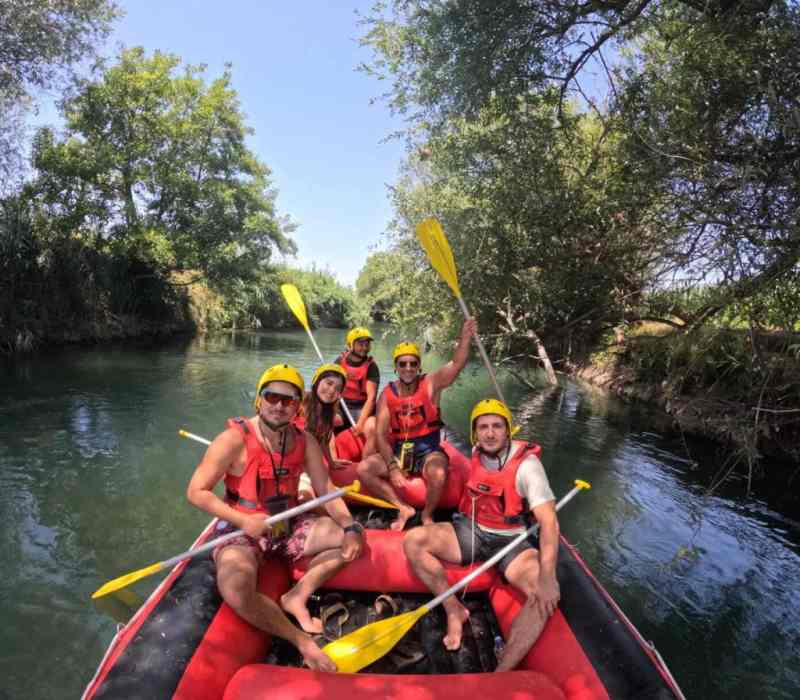 Rafters paddling through the calm green water of the Bistrica River near Saranda