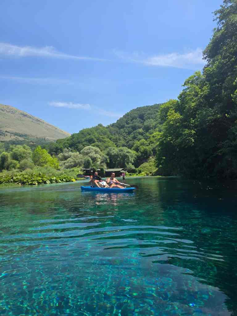 Kayakers on the clear Blue Eye water among green hills near Saranda