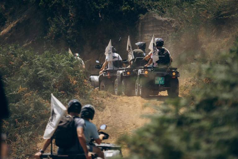 Quad bikes riding along a dusty coastal trail at Cape of Rodon