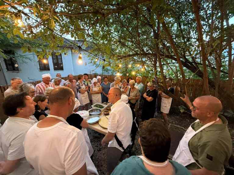 A group cooking together at tables in a Gjirokastra courtyard