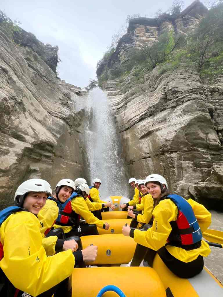A group of rafters in yellow gear paddling through the Osum Canyon near Berat