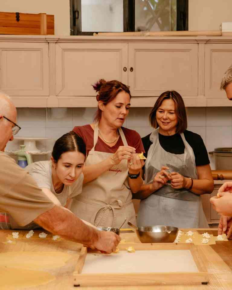 Small group making dough with a host at a hands-on cooking class in Tirana