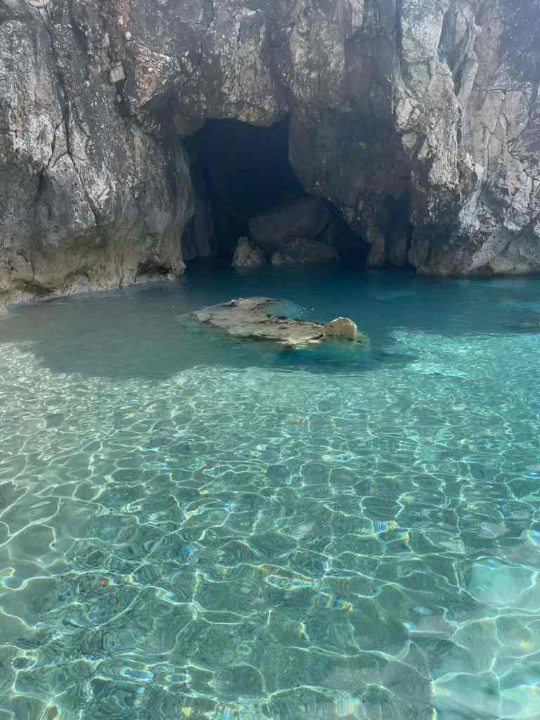 Clear shallow turquoise water at the mouth of a sea cave on a Himara boat tour along the Albanian Riviera