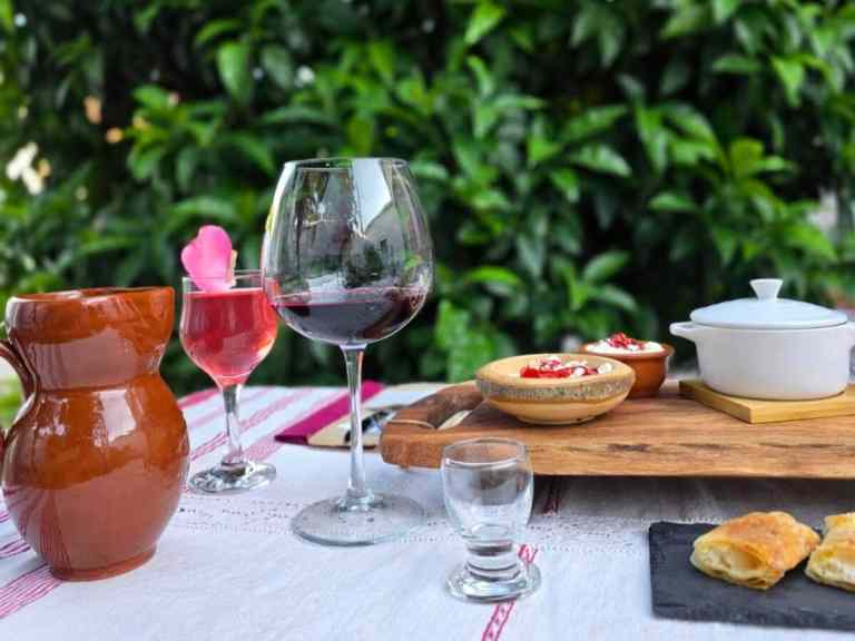 Rustic table with a clay jug, wine and bread at a home meal in Shkodra