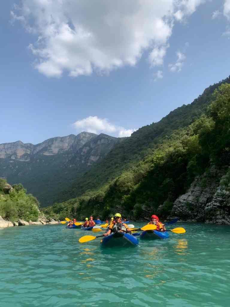 Two kayakers on calm turquoise water on the Vjosa river near Përmet
