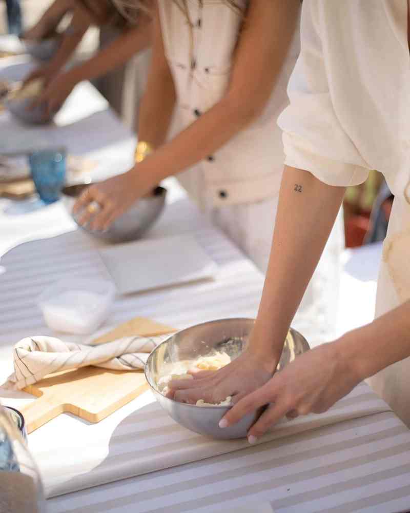 Hands shaping traditional dough on a board at an Albanian cooking class in Tirana