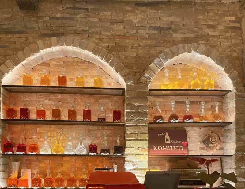 Shelves of colourful raki and spirits at a tasting bar in Vlora