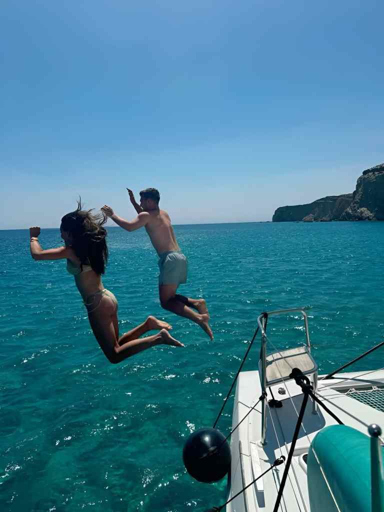 A traveller jumping off a boat into the clear Ionian Sea on a Saranda boat tour, Albania