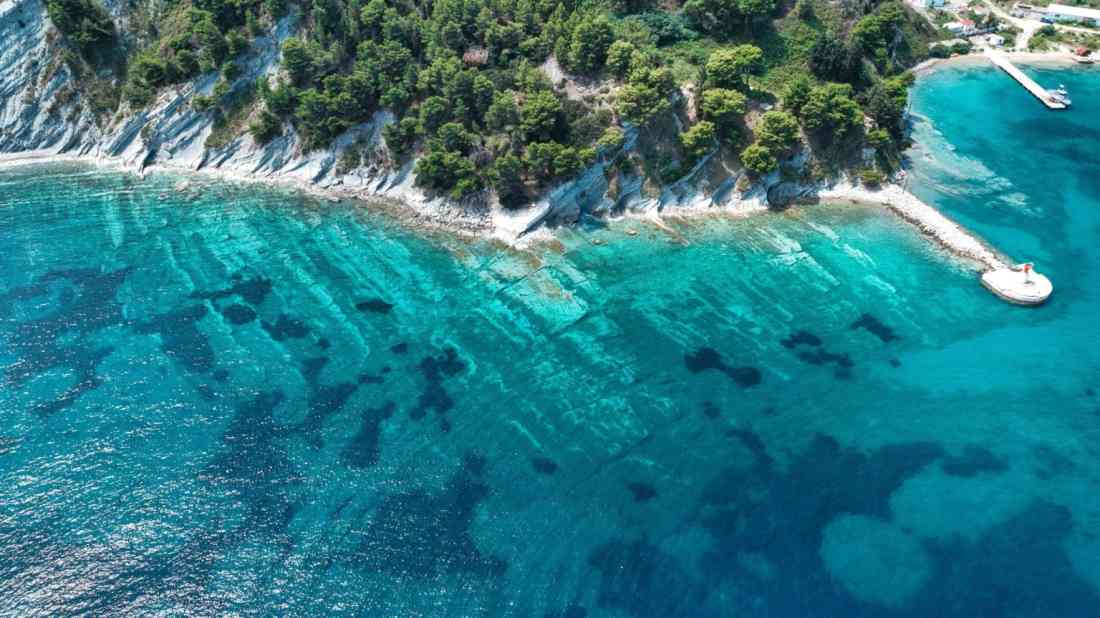Aerial view of a tour boat on the bright turquoise water off Sazan Island near Vlora