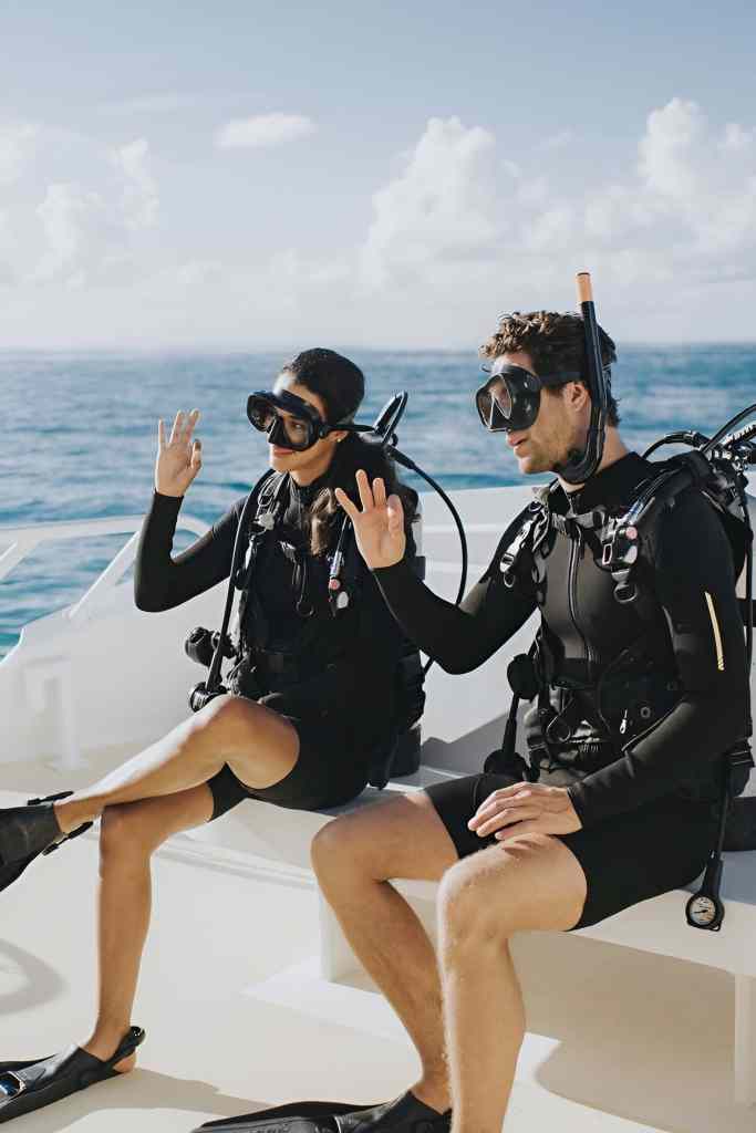 Two scuba divers in gear giving thumbs up on a boat at sea on the Albanian Riviera