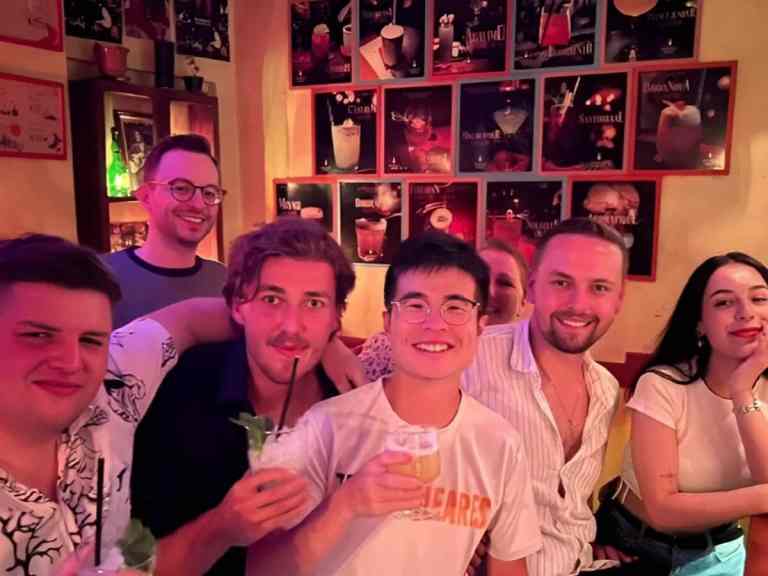 Group of friends posing with drinks at a bar in Blloku, Tirana