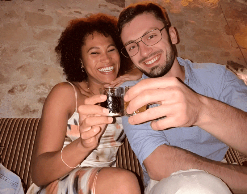 A couple toasting with small glasses of raki at a tasting in Tirana