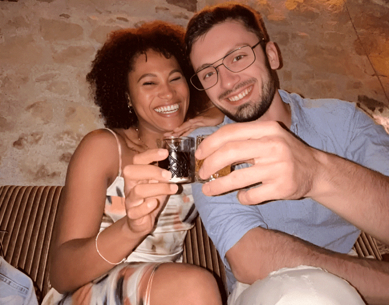 A couple toasting with small glasses of raki at a tasting in Tirana