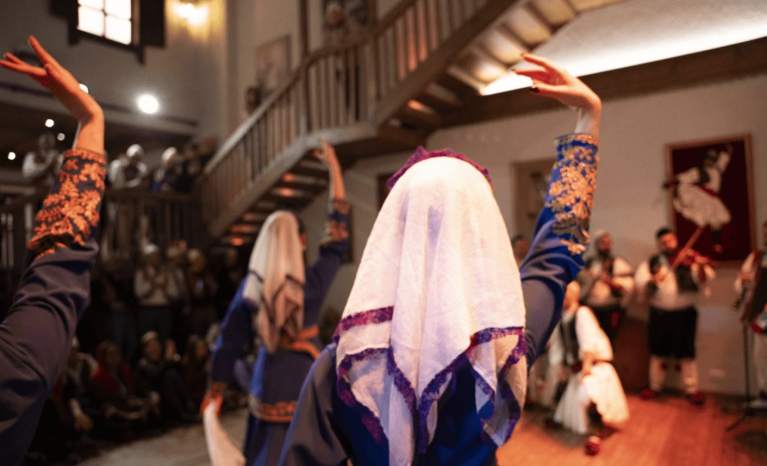 Traditional Albanian wedding dance performance with a veiled bride figure at a night show