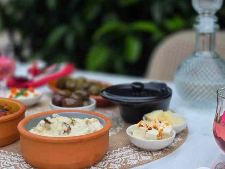 Clay pots of dips and cheese with byrek on a table at a Shkodra food tasting