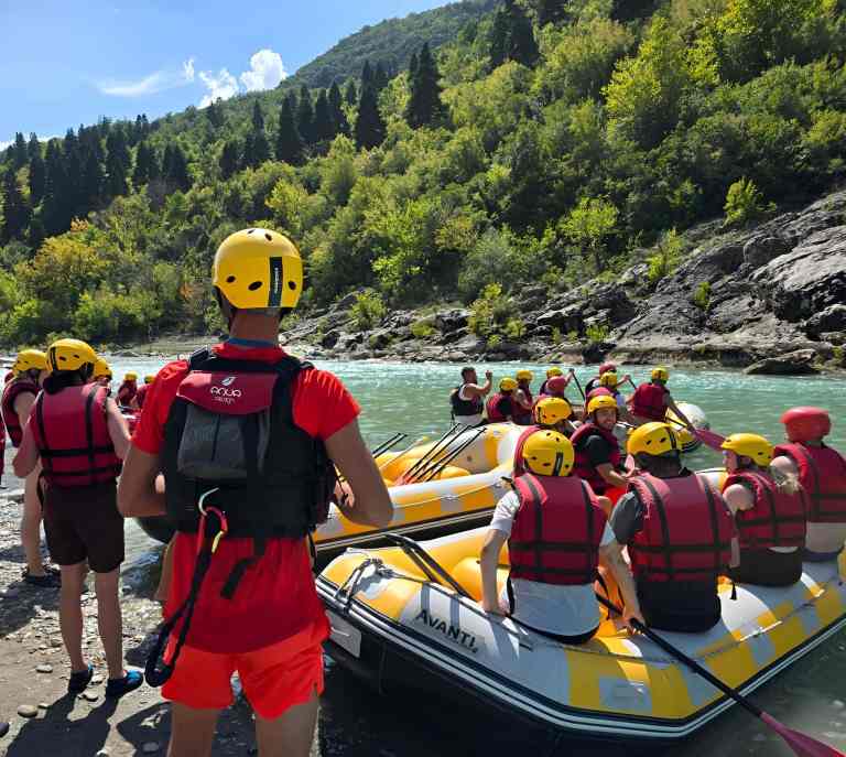 Family rafting together on a yellow raft on the Vjosa River near Gjirokastra