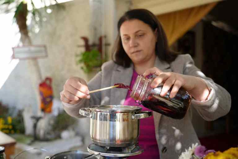 A woman dyeing wool with a pot in a village near Gjirokastra