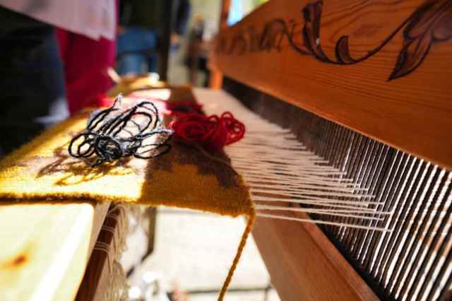 A traditional wooden weaving loom set up with thread in Lazarat