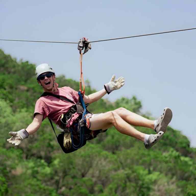 Person ziplining over the green hills outside Tirana