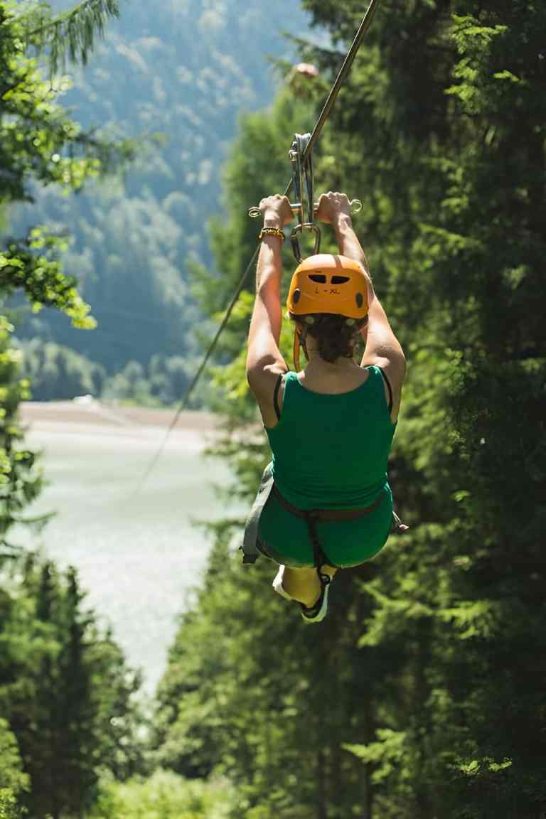Person ziplining over a green hillside near Tirana