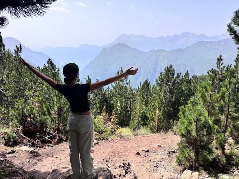 Hiker at the viewpoint above Lepushe with the Accursed Mountains behind