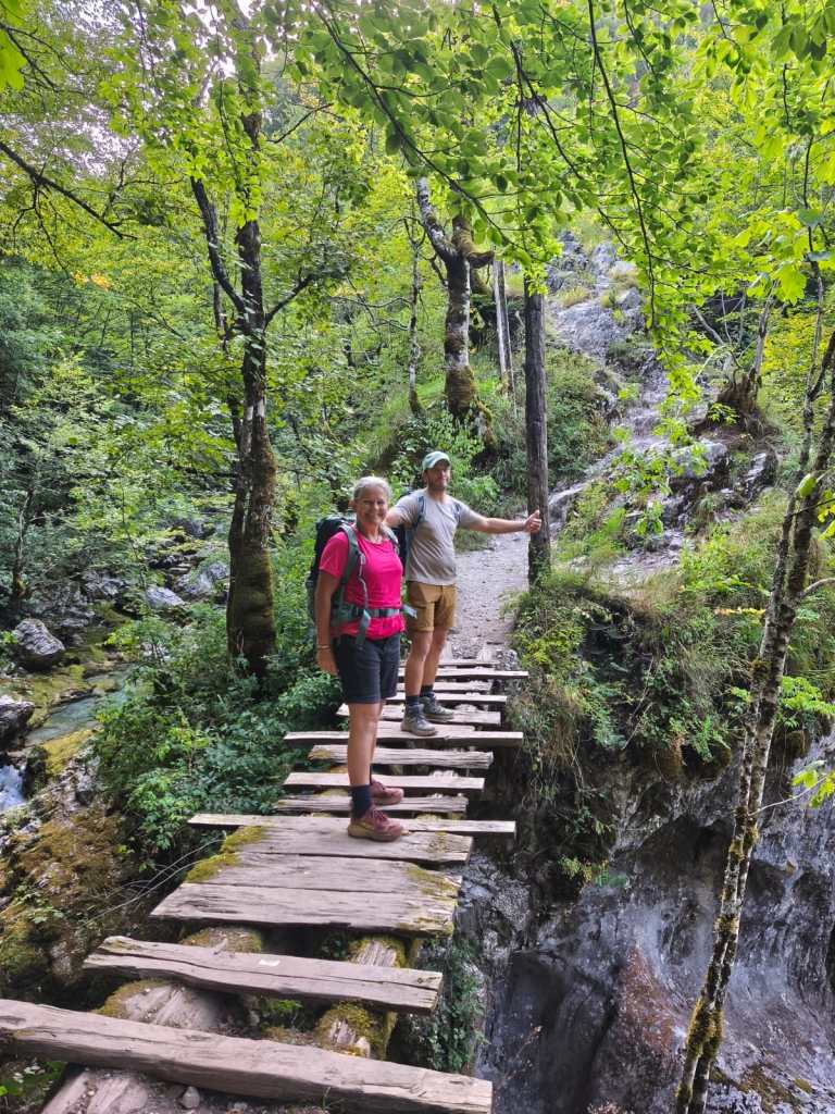 Two hikers on the wooden walkway of the Blue Eye trail in Theth