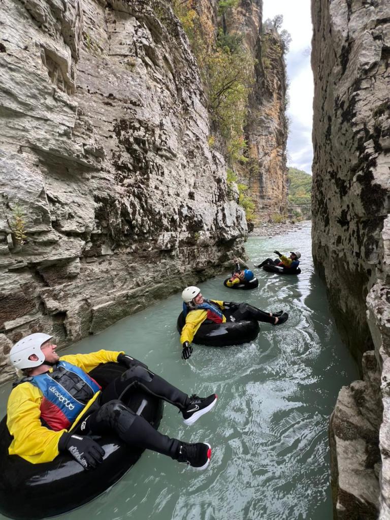 Traveller in a helmet and life jacket river tubing between the cliffs of Osum Canyon near Berat, Albania